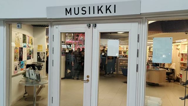 vídeo desde fuera de una sala con el cartel "Musiikki" (Musica) donde se escucha heavy metal