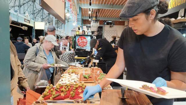 Waiters serving customers some tapas/pintxos (see other alt text for details of the composition)